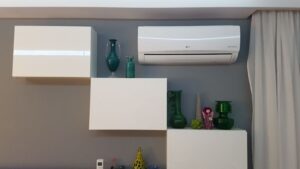 Klimatyzator LG Inverter na ścianie w mieszkaniu zainstalowany pomiędzy szafkami.